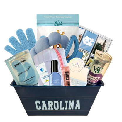 UNC Chapel Hill gift basket full of Carolina blue gifts for girls who enjoy self care, including a Tar Heels game day bracelet, UNC chocolates, cosmetic items, and made in North Carolina snacks