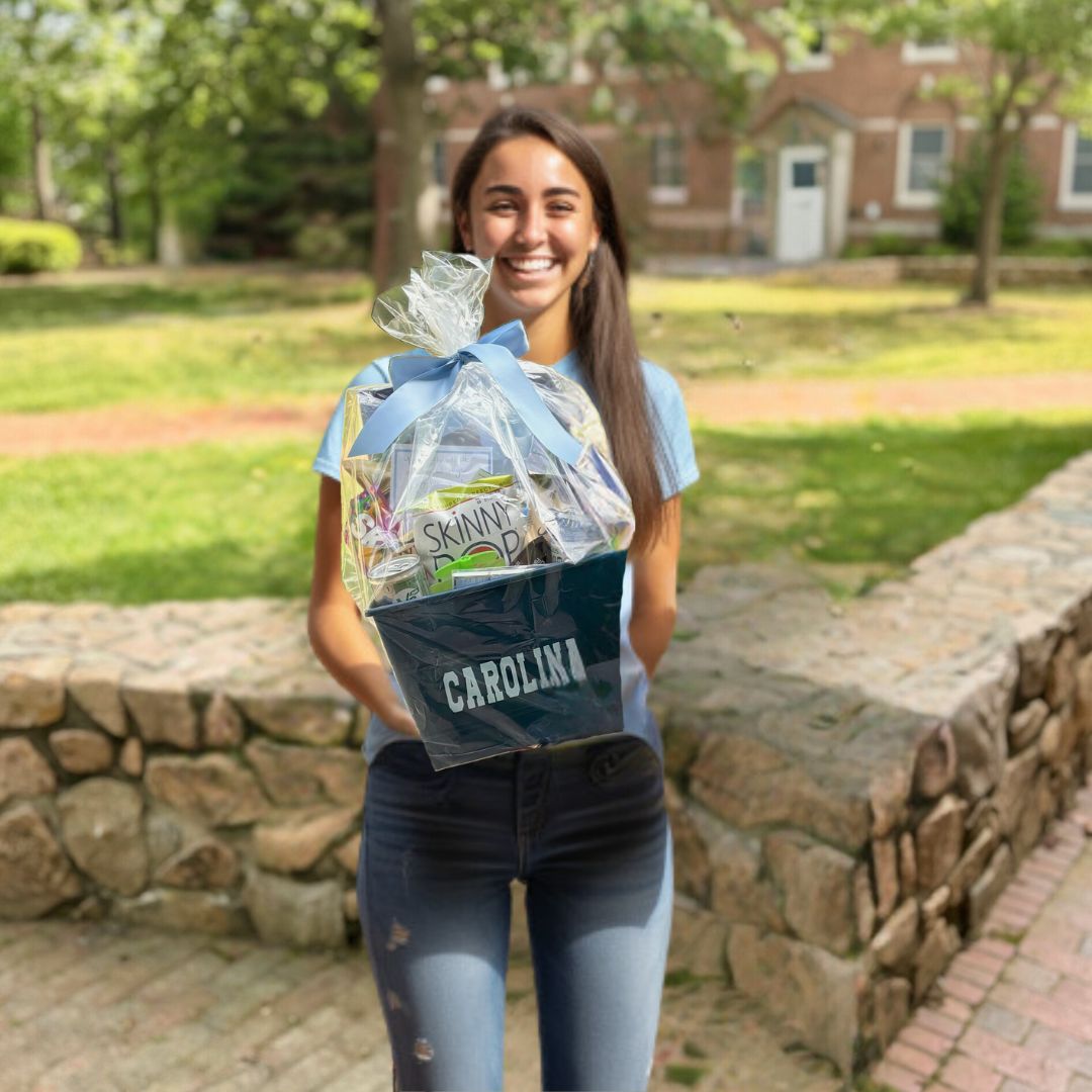 University of North Carolina at Chapel Hill student holding a UNC themed care package